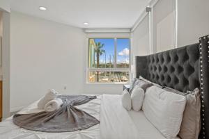 a bedroom with a large white bed with a window at Venice Marina Water Front Luxury Condo in Los Angeles