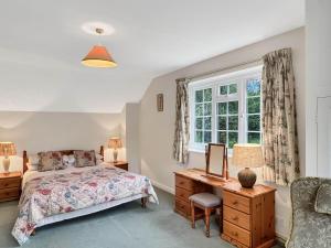 a bedroom with a bed and a desk and a window at Wey House Withypool in Withypool