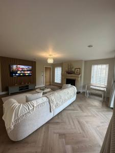 a large living room with a couch and a tv at Luxury Sunrise Guest House County Down in Killyleagh