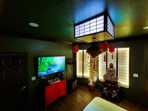 a living room with a flat screen tv next to a window at Asian Zen Den in Sparks