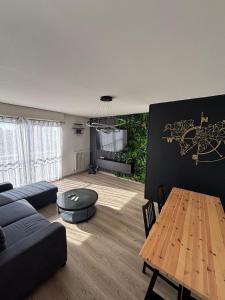 una sala de estar con un sofá y una mesa en Appartement d Alex, en Joué-lès-Tours