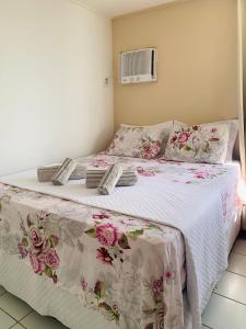 a bedroom with a bed with a white and pink blanket at Residencial Neo 1 in Maceió