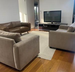 een woonkamer met twee banken en een flatscreen-tv bij Bayview Villa Portarlington in Portarlington