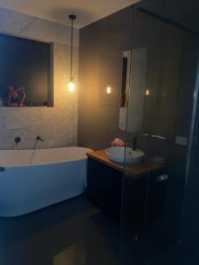 een badkamer met een ligbad en een wastafel bij Bayview Villa Portarlington in Portarlington +11 foto's