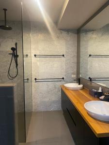 een badkamer met een glazen douche en een wastafel bij Bayview Villa Portarlington in Portarlington