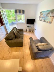 Una sala de estar con un sofá y un televisor. en Little Wight House - Yarmouth, en Freshwater