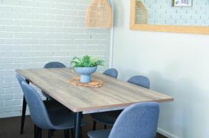 a wooden table with chairs and a potted plant on it at Bathurst Motor Inn in Bathurst