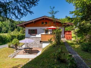 a cottage with a table and an umbrella in front of it at Haus Weissbach in Leogang