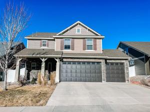 a house with two garage doors on a driveway at Spacious Family Getaway 20min to downtown sights in Fountain