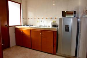 a kitchen with a stainless steel refrigerator and a sink at Apartahotel Doble3 in Paipa