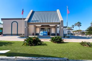 a gas station with two flags in front of it at Best Western Port Aransas in Port Aransas
