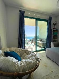 ein Wohnzimmer mit Couch und Blick aufs Meer in der Unterkunft Apartamento Atrium Vistas al mar en Finestrat in Cala de Finestrat
