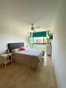 ein Schlafzimmer mit einem Bett und einem großen Fenster in der Unterkunft Apartamento Atrium Vistas al mar en Finestrat in Cala de Finestrat