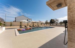 a swimming pool with a camera on a building at Amazing Home In Biograd Na Moru in Biograd na Moru +40 photos