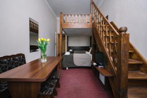 a room with a desk and a staircase with a bed at Rembrandt Aparthotel in Kraków