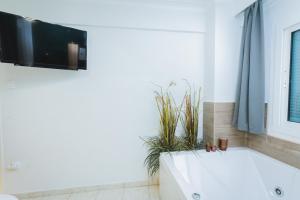 łazienka z wanną i telewizorem na ścianie w obiekcie Emerald Oasis by Nexus, 5 min to White Tower w Salonikach +24 zdjęcia