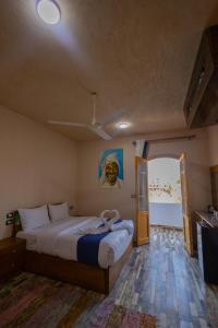 ein Schlafzimmer mit einem Bett und einem Gemälde an der Wand in der Unterkunft ACHERTOD Nubian House in Naj‘ al Maḩaţţah + 76 Fotos