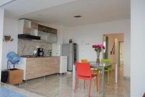 a kitchen with a table and chairs and a refrigerator at Apto 301 - Remodelado, iluminado y buena vista - Casa Orquídeas in Fusagasuga +20 photos