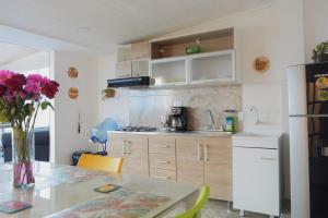 a kitchen with a table with a vase of flowers at Apto 301 - Remodelado, iluminado y buena vista - Casa Orquídeas in Fusagasuga