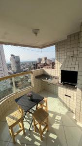 a room with a table and two chairs on a balcony at Apto com Ar condicionado e churrasqueira in Praia Grande