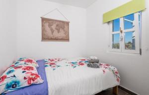 a bedroom with a bed with floral sheets and a window at Holiday house with a parking space Sveti Jakov, Losinj - 24017 in Sveti Jakov