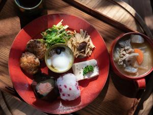 a red plate of food on a wooden table at Nunoya Ryokan in Matsumoto