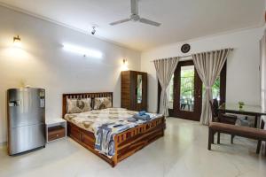a bedroom with a bed and a refrigerator at Dream key suits in Siolim +7 photos