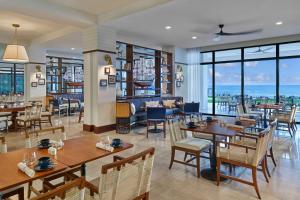 Saint GeorgeThe St. Regis Bermuda Resort的餐厅设有桌椅和窗户。