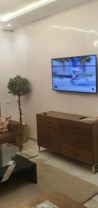 a living room with a couch and a tv on a wall at Aerostay Jamal in Dah Hammou Ben Cheïkh