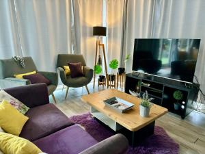 a living room with a couch and a tv at Casa moderna en el bosque y montaña in Villa La Angostura