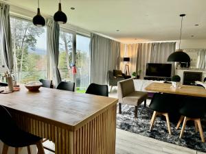 a living room with a table and chairs and a living room at Casa moderna en el bosque y montaña in Villa La Angostura