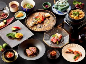 uma mesa coberta com pratos de comida e tigelas de comida em Hotel Grand Tiara Minaminagoya em Anjomachi