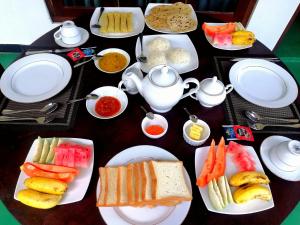 a table with plates of food on a table at Mountain Breeze Villa in Ella