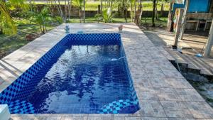 a swimming pool with blue tiles on the ground at Chácara Aconchegante para COP 30 in Belém