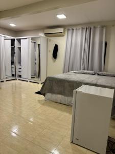 Un dormitorio con una cama y una mesa dentro. en Chácara Aconchegante para COP 30, en Belém