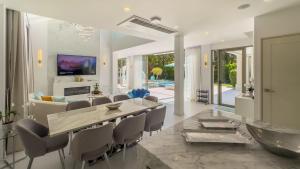 une salle à manger et un salon avec une table et des chaises dans l'établissement Beachfront Luxury villa near Banyan Tree, à Layan Beach