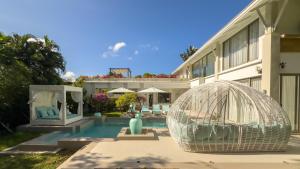 - une piscine avec une cage pour oiseaux à côté d'un bâtiment dans l'établissement Beachfront Luxury villa near Banyan Tree, à Layan Beach
