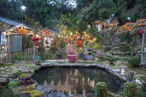 a garden with a pond with lights in it at Gobies Garden in Mộc Châu