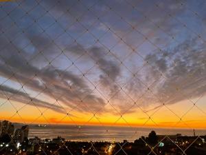 a fence with a sunset in the background at Departamento Familiar con vista al Mar in Viña del Mar