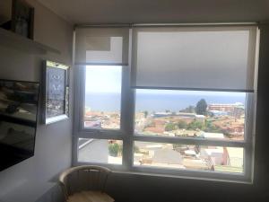 a window with a view of a city through it at Departamento Familiar con vista al Mar in Viña del Mar