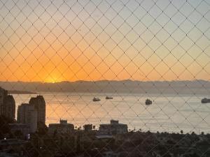 a fence with a view of the water with boats at Departamento Familiar con vista al Mar in Viña del Mar