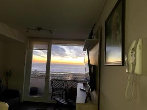 a room with a phone and a view of the ocean at Departamento Familiar con vista al Mar in Viña del Mar