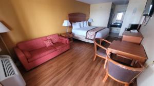 a hotel room with a bed and a couch and a table at Americas Best Value Inn Frost Bank Center in San Antonio