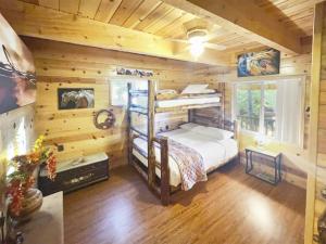 Un dormitorio con una litera en una cabaña de madera en Modern Family Cabin with Deck, BBQ, Views and Playroom, en Duck Creek Village