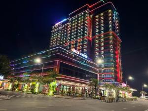 a tall building with lights on it at night at Flamingo Hải Tiến - Sỏi Apartment in Gò Ba Quần