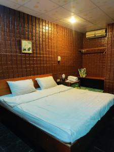 a bedroom with a large bed with a wooden wall at Rim Than View Resort in Ubon Ratchathani