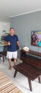 a man is standing next to a bench at Maravilha do Patacho in Pôrto de Pedras