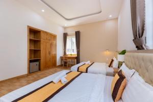 a hotel room with two beds and a desk at Biệt thự 25 Lạc Long Quân in Vung Tau +60 photos