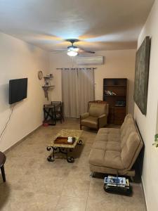 a living room with a couch and a tv at Apartamento Completo Cabo San Lucas in Cabo San Lucas