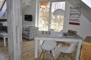 a white dining room with a table and chairs at Apartament w kratkę in Dębki
